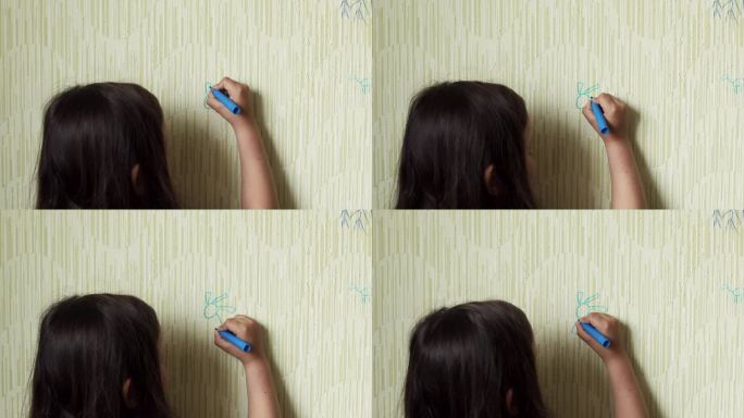 黑头发的小女孩用蓝色记号笔在旧墙纸背面画出快乐的太阳，施展艺术技巧。空间绘画，无序行为，绘画，挂纸损