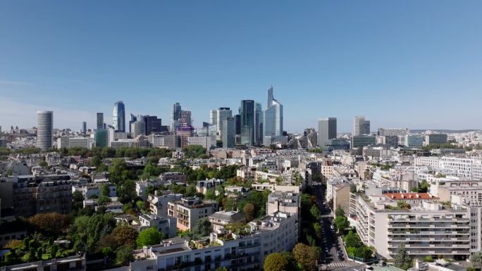 飞越居民区，背景是拉德芳斯的现代商业摩天大楼群。法国巴黎