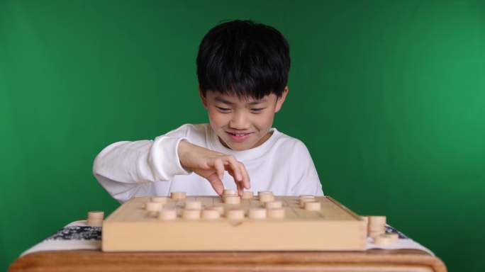 中国小男孩在下棋中国象棋举棋不定