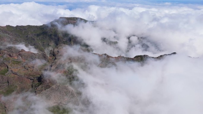 史诗般的马德拉岛景观从空中透视。巨大的岩石山峰覆盖着漂浮的云。阳光明媚的白天，在Pico do Ar