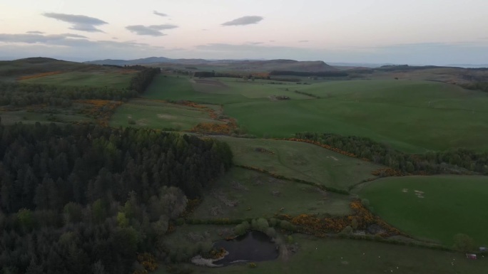 苏格兰牧羊场的鸟瞰图，概括了乡村的美丽，农业和自然在无缝舞蹈中共存。