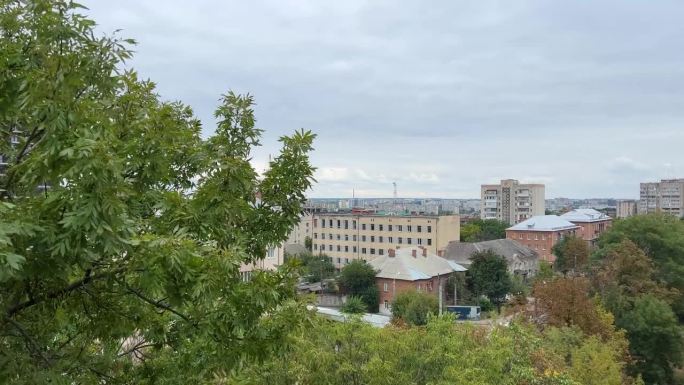 在乌克兰文尼察市的一个摩天轮上拍摄的视频，古老的景点俯瞰城市，高大的铁轮在公园里五颜六色的篮子，绿色