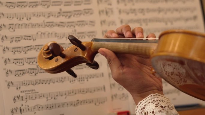 小提琴演奏的特写，背景是乐谱。仪器的特写镜头。