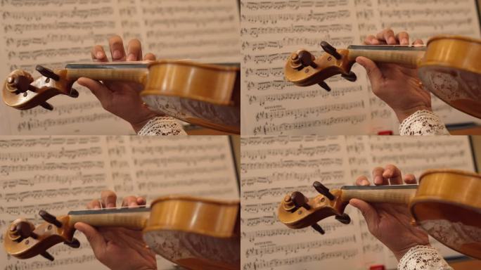 小提琴演奏的特写，背景是乐谱。仪器的特写镜头。