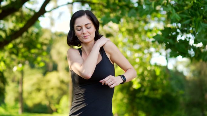 年轻的女运动员在城市公园晨跑锻炼时，肩膀剧烈疼痛。