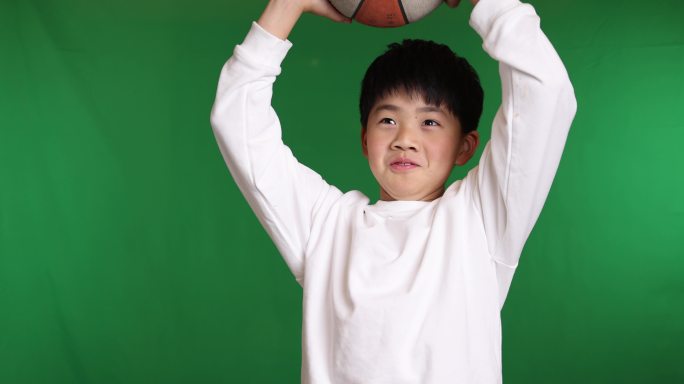 帅气的中国小男孩在玩篮球投篮慢镜头