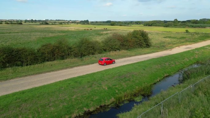 英国诺福克郡乡间的红色轿车。空中无人机