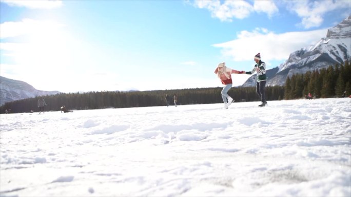 慢镜头:一对幸福的夫妇在结冰的湖面上滑冰