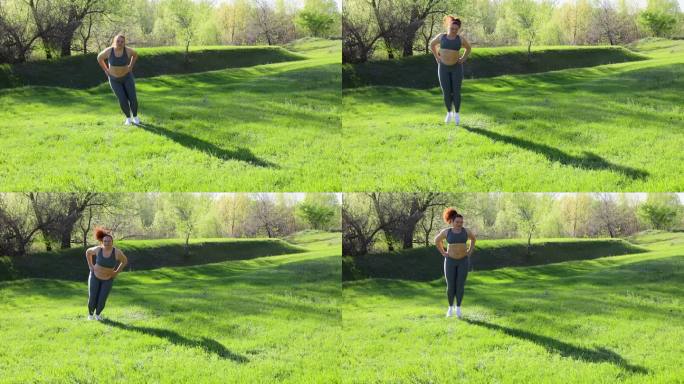 在阳光明媚的日子里，穿着健身服的年轻超重女子在公园的绿色草坪上左右跳来跳去，慢动作。健康的生活方式，