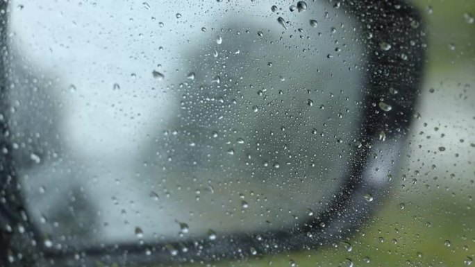 窗外下雨，从汽车后视镜里看高速行驶的汽车，在汽车里行驶的汽车，在雨中行驶的汽车，天气