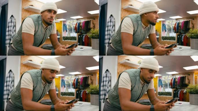 Pop - Up Fashion或服装店收银台的男销售助理正在看手机