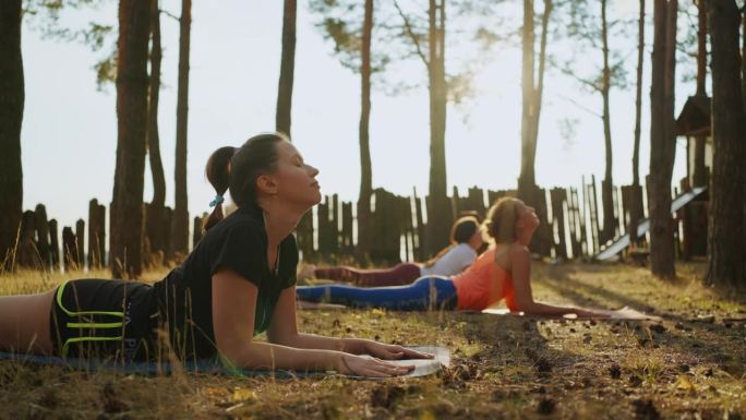 在夏令营里，妇女们躺在地上练习瑜伽