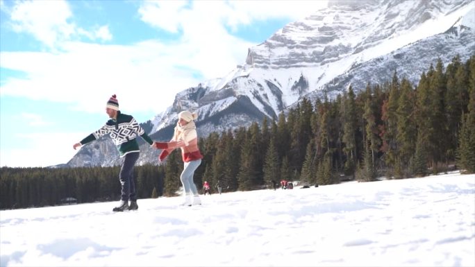慢镜头:一对幸福的夫妇在结冰的湖面上滑冰