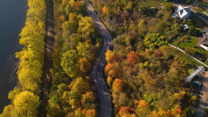 在立陶宛考纳斯，汽车沿着尼里斯河行驶在与铁路相邻的道路上的航拍画面