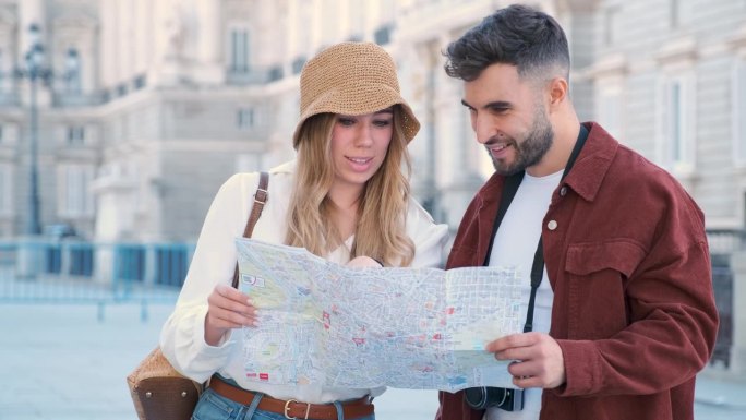 一对年轻的高加索夫妇在地图上寻找西班牙马德里。