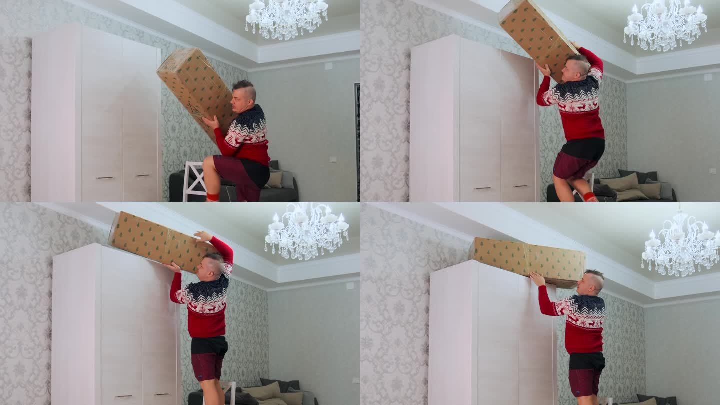 圣诞节假期结束，男人又大又重的箱子用一棵人造圣诞树放在架子上