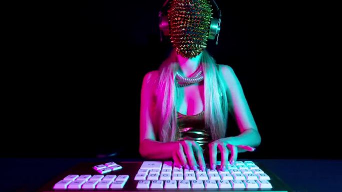 电脑上戴着金色尖尖面具的女性