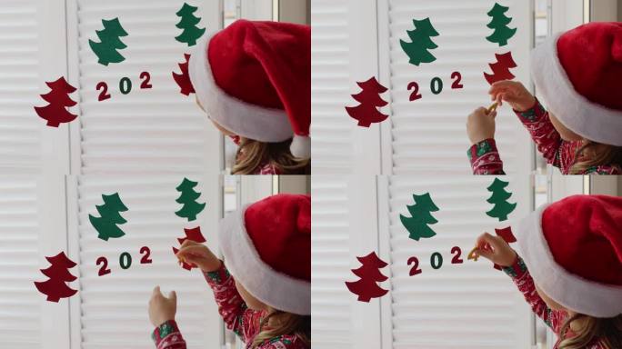 小女孩戴着红色的圣诞老人帽子装饰冬季度假屋，为新年派对手工纸花环数字2024圣诞树。孩子们自己动手做