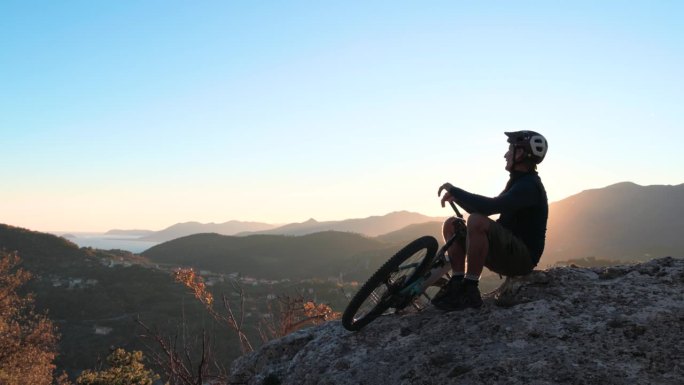 成熟的男子骑自行车探索高山山腰，秋天