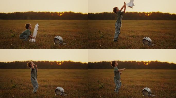 夏天，小男孩在户外玩玩具火箭，孩子在草地上扔宇宙飞船