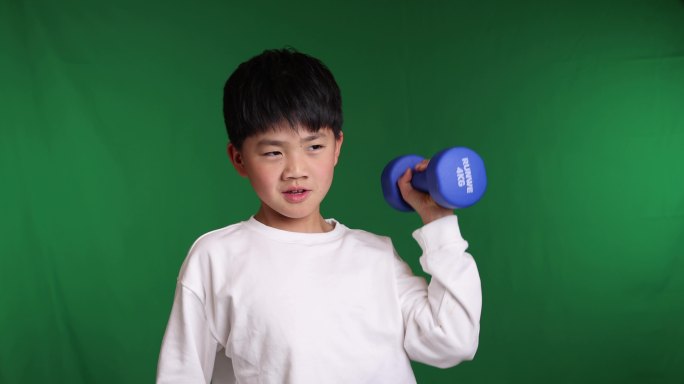 帅气的中国小男孩在举哑铃锻炼身体