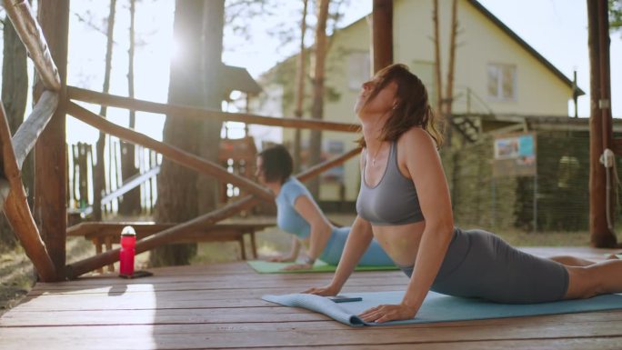 成年女性在健身营训练，练习瑜伽以获得良好的体型和健康