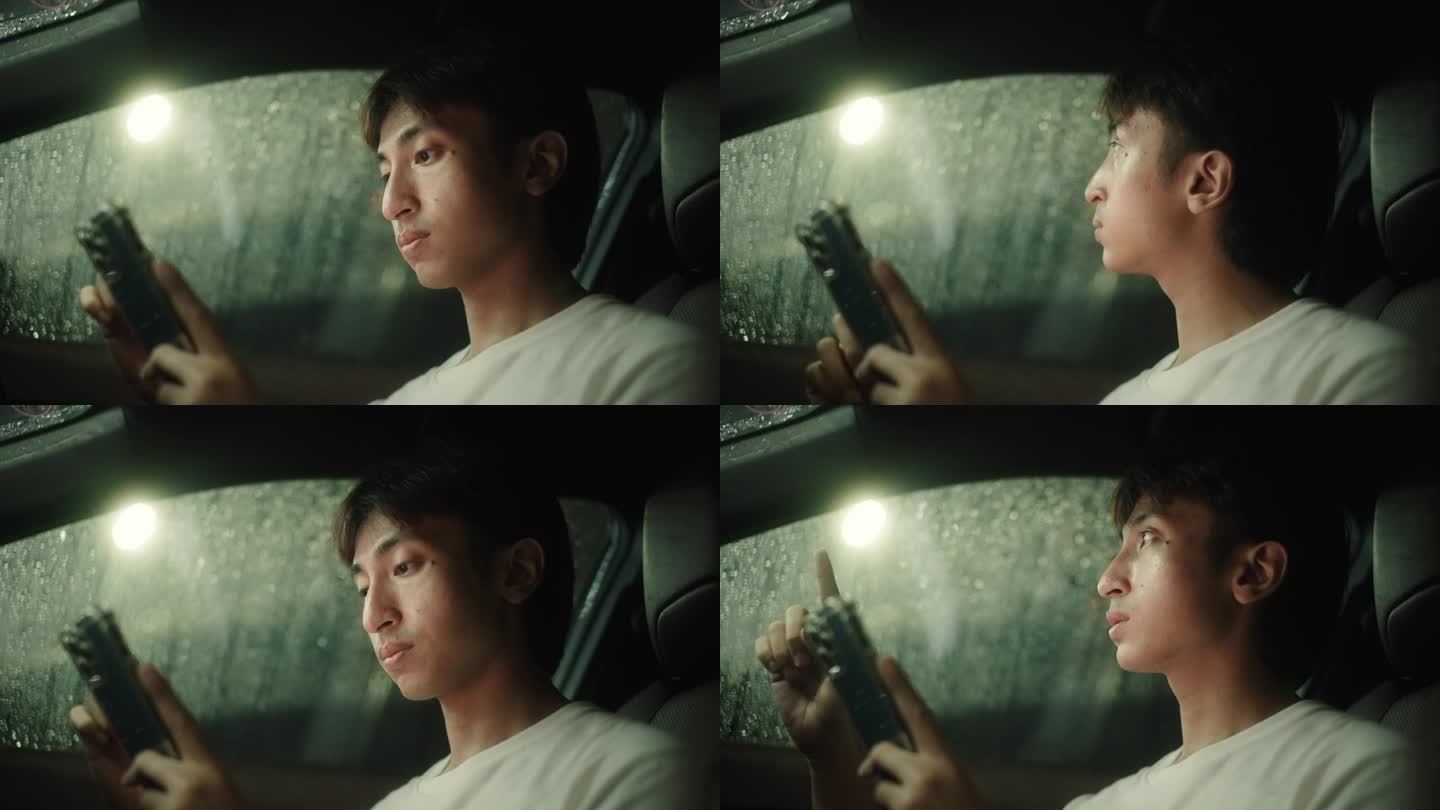 男子下雨天在车里玩智能手机。