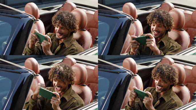 男子坐在车里赢得手机视频游戏。印度男司机坐在敞篷车里玩智能手机游戏。
