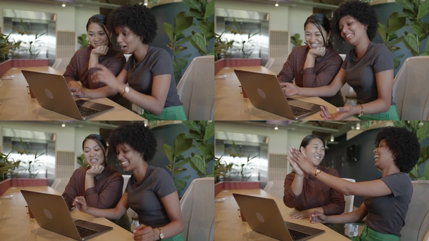 年轻的女商人在办公室休息室用笔记本电脑工作时大笑