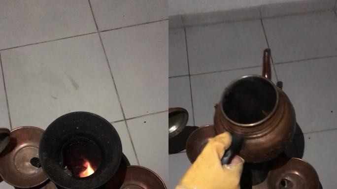 木头上的土耳其茶炊。一个人把开水倒进壶里，放在火上。外面是晚上。垂直视频。