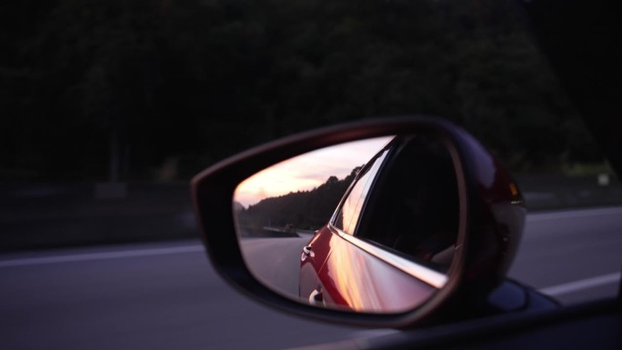 路边后视镜在汽车上的反射。
落日映照在红色汽车的后视镜里。