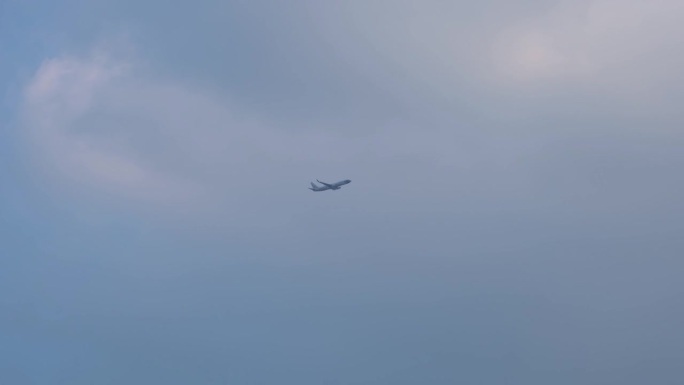 从泰国曼谷廊曼国际机场起飞的诺克航空公司在穿过深灰色云层进入白色明亮云层的过程中爬升并提高高度