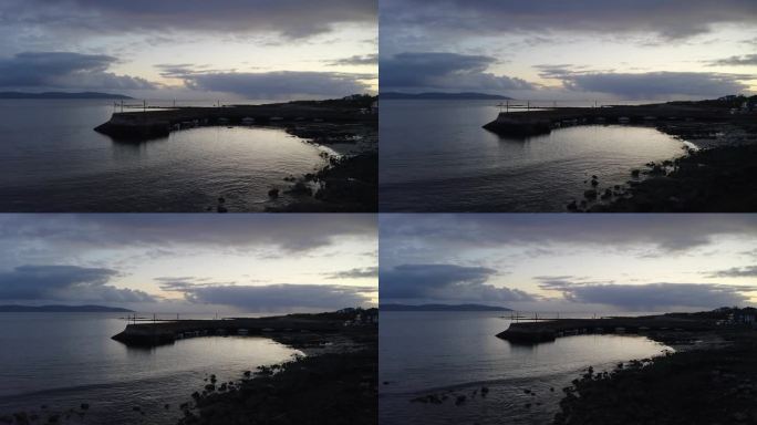 黄昏时分，无人机从爱尔兰戈尔韦的巴纳码头撤退，光线反射在海洋上