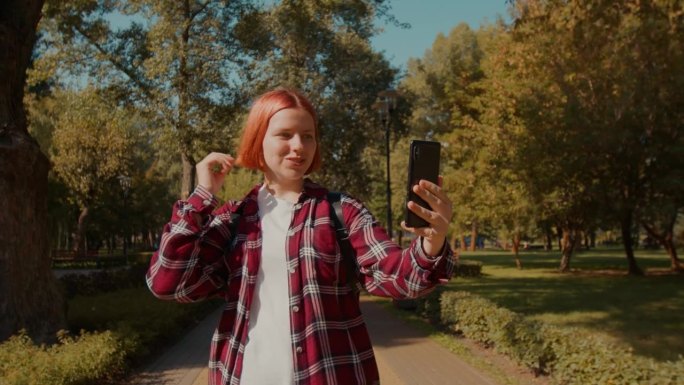开朗可爱的听障少女在散步时用手机打视频电话