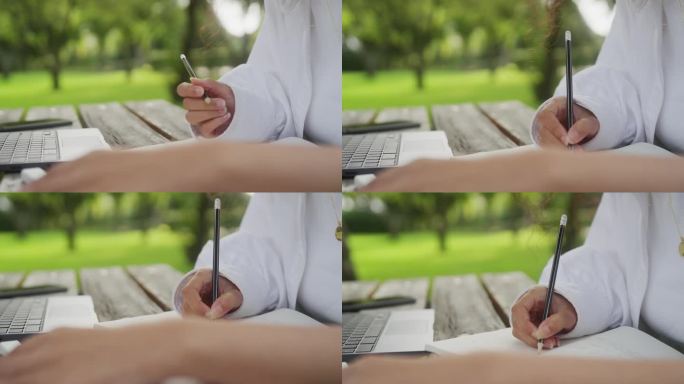 一位女士用铅笔在笔记本上写字