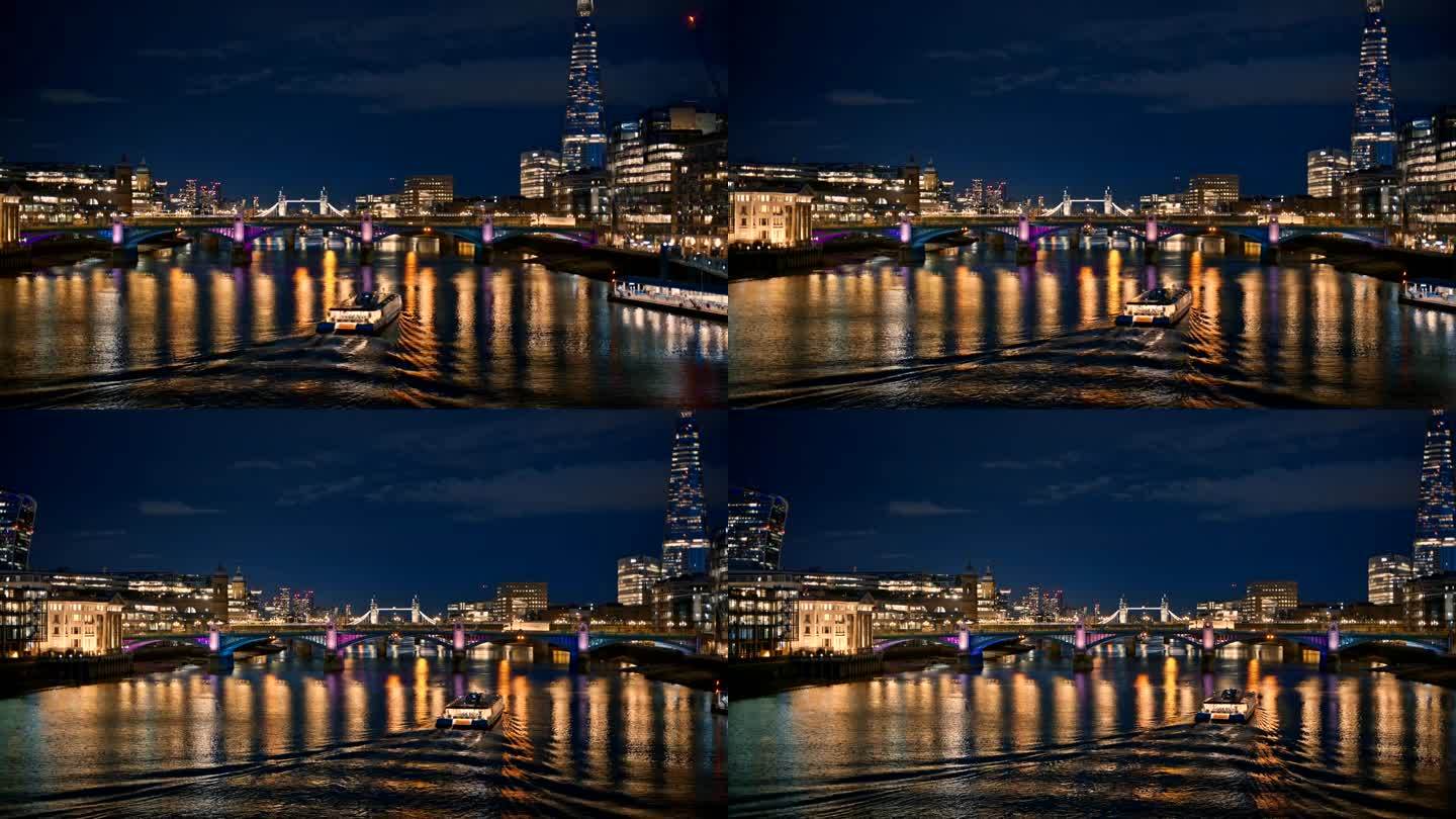 英国伦敦泰晤士河的夜景。漂浮的船，远处的桥梁和塔桥，两侧的碎片摩天大楼等建筑，照明很多
