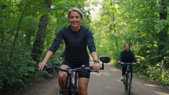 夏天在森林里骑自行车的快乐运动女人的肖像，周末的运动和娱乐