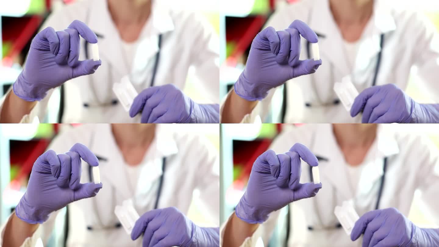 戴手套的妇科医生医用蜡烛和阴道药片