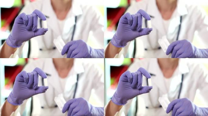 戴手套的妇科医生医用蜡烛和阴道药片