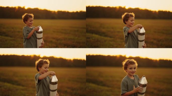 小男孩玩着手工玩具火箭，梦想着太空旅行，田野里的孩子肖像