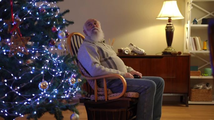 一个大胡子老头坐在摇椅上，聚精会神地看了看身边的圣诞树，然后起身离开了。
