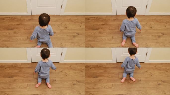 有趣的婴儿坐在地板上跪着爬。一个孩子在家里的客厅里异常地弯着腿走路。2岁左右(1岁9个月)