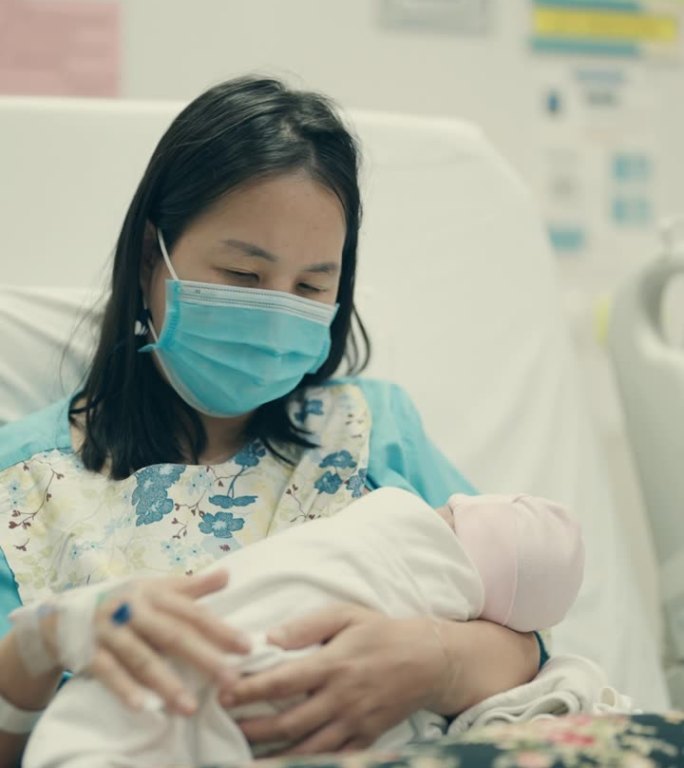 医院里的亲密关系:亚洲母亲母乳喂养婴儿。
