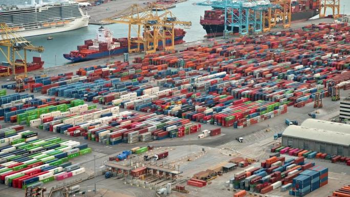 西班牙，巴塞罗那海港，有大量的集装箱，停泊的船只，移动的卡车
