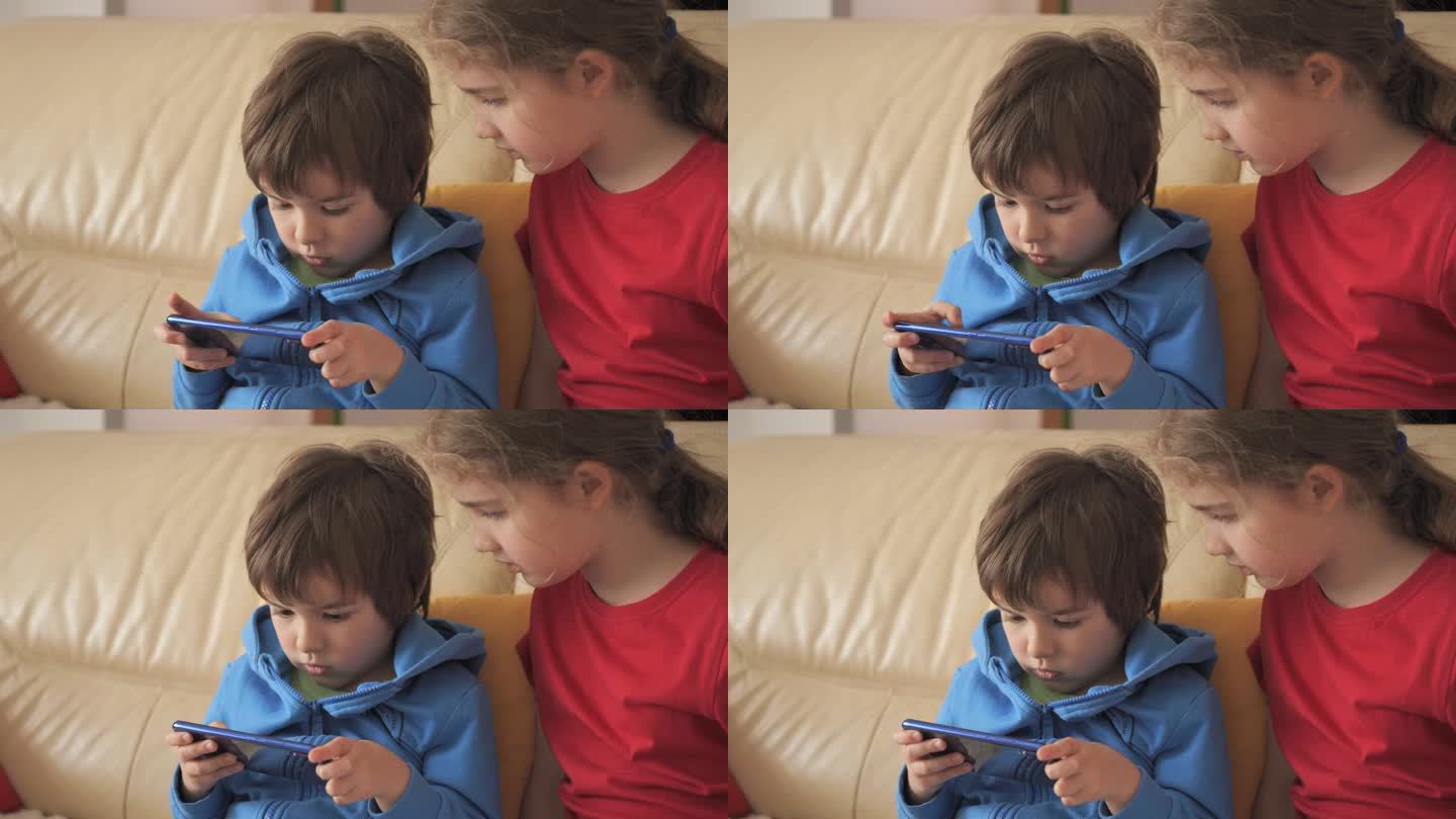 孩子们在家沙发上玩手机游戏。孩子们在手机上玩电子游戏。男孩和女孩在沙发上玩电子游戏智能手机朋友用手机