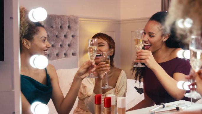 一群女性朋友在家里准备晚上出去喝香槟