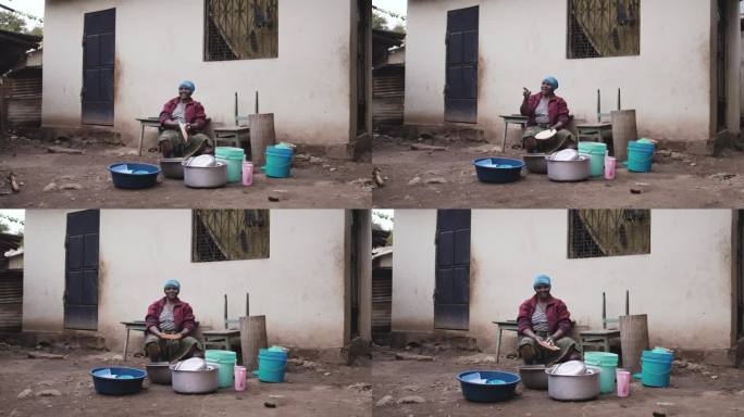 慢镜头，一个女人一边清洗餐具一边说话。微笑的女人在外面洗盘子。她在房子外面。