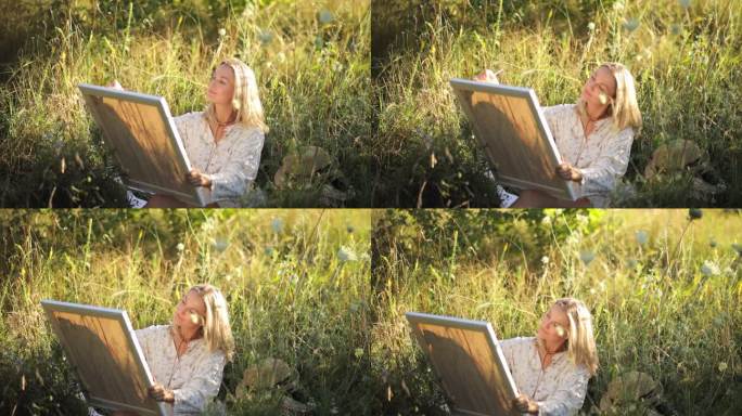 富有创造力的美丽女艺术家在森林户外用丙烯颜料作画。