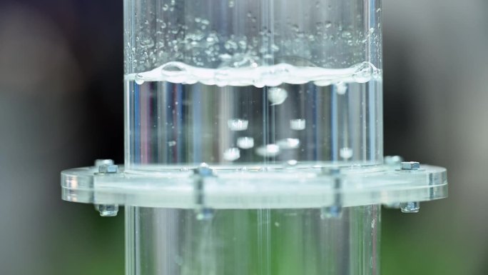 氢气在装满水的塑料瓶中通过薄膜起泡，小气泡在液体中形成，慢动作