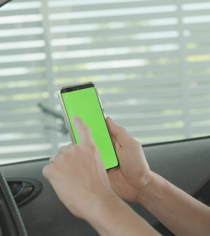男子在车里使用绿屏智能手机，出门前查看手机应用